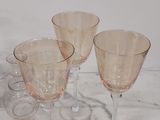 three wine glasses sitting on top of a marble counter top