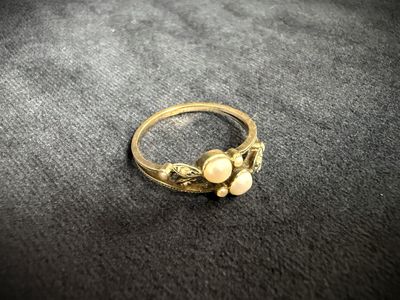 a close up of a gold ring with pearls on it