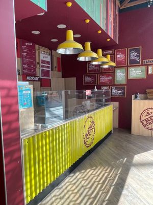 un comptoir jaune et rouge au milieu d'un restaurant