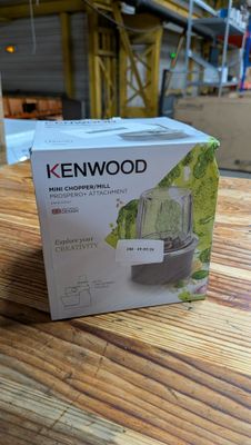 un carton contenant un mixeur Kenwood posé sur une table en bois