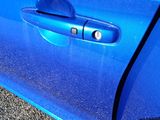 a close up of a blue car door handle