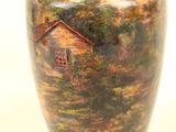a large vase with a painting of a house on it