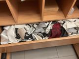 a drawer full of clothes and a hat in a room