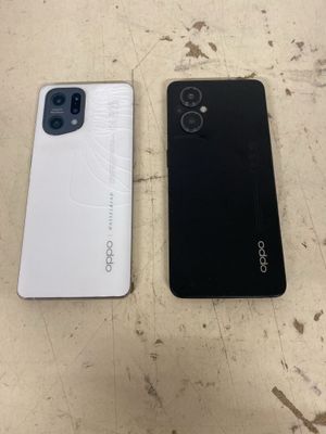 deux smartphones, l'un blanc et l'autre noir, posés côte à côte sur une table