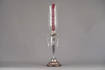 a silver vase with a red candle inside of it