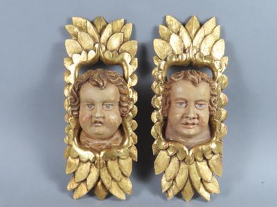 paire de têtes anciennes dorées à la feuille, aux yeux bleus, sur fond bleu