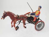 a figurine of a man riding in a horse drawn carriage