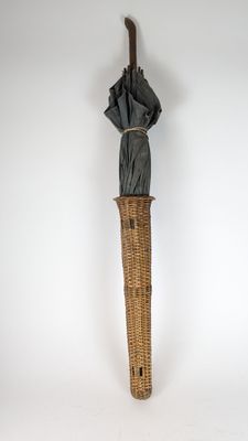 a wicker umbrella that is hanging on the wall