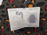 two tags on the back of a backpack that are attached to the back of a backpack