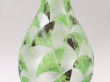 a glass vase with a green and white design on it