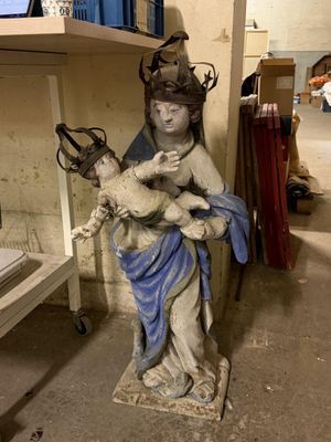 une statue représentant une femme tenant un bébé dans une pièce