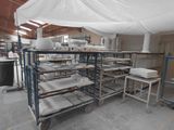 a large room with a lot of tables and chairs under a white tarp