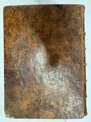un vieux livre posé sur une table blanche recouverte de poussière
