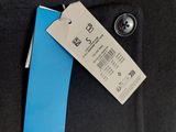 the jacket is black and has a blue tag attached to it