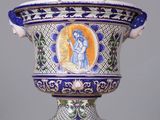a blue and white vase with a picture of a woman on it