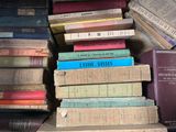 many books stacked on top of each other on a shelf