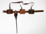une vieille ceinture en cuir à laquelle sont fixés un couteau et deux étuis