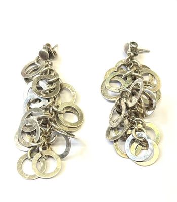 deux paires de boucles d'oreilles posées sur une surface blanche