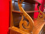 a wooden dresser with a red wall in the background