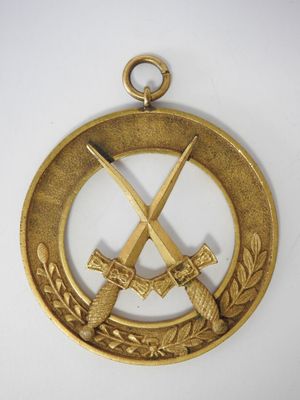 médaille d'or représentant deux épées croisées et des branches de laurier sur fond blanc