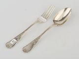 two forks and a spoon on a table with a price tag on it