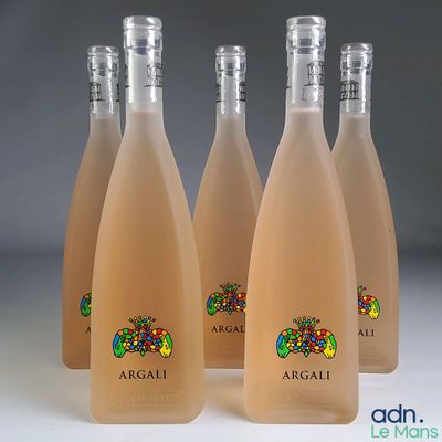 quatre bouteilles de vin sont alignées sur une table