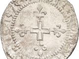 a close up of a coin with a cross on it