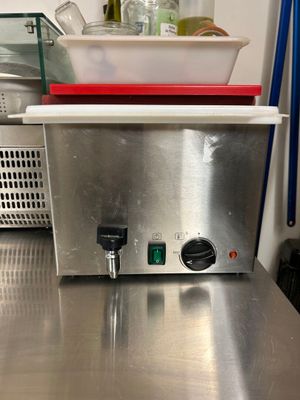 plan de travail en acier inoxydable dans une cuisine professionnelle, sur lequel est posé un saladier