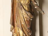 a statue of a woman holding a cross on a table