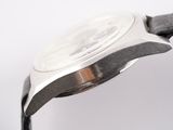 wrist of a watch with a black band and a silver face