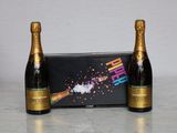 two bottles of champagne sitting next to each other on a table