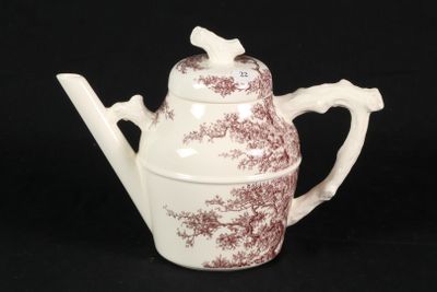 brown and white teapot with a bird on it on a black background