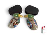 two pairs of earrings with colorful designs on them sitting next to each other