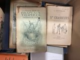 several books are stacked on top of each other in a box