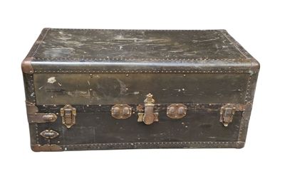 une vieille valise posée sur une surface blanche