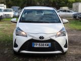 a white toyota yaris parked on the side of the road