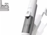 un aspirateur posé par terre à côté d'une brosse à dents et d'un tube de dentifrice