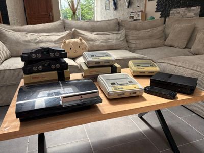 a coffee table that has a bunch of nintendo game consoles on it