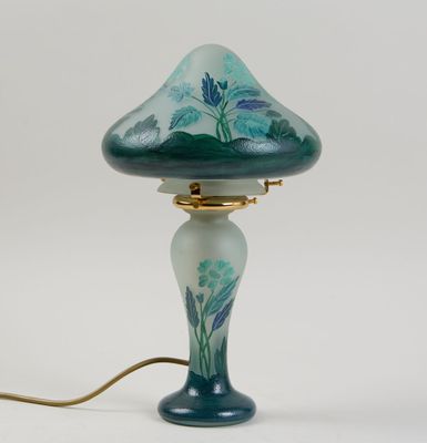 une image représentant une lampe dotée d'un abat-jour en verre bleu et vert
