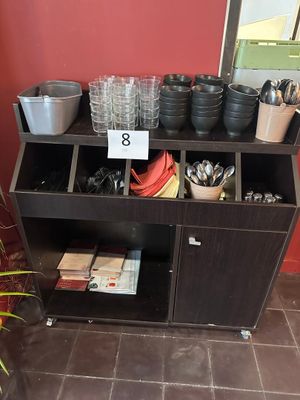 une étagère sur laquelle sont posées des casseroles et des poêles, dans une pièce