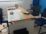 a desk with two chairs and a table with papers on it