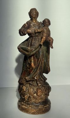 statue en bronze représentant une femme tenant un enfant dans ses bras, posée sur un socle