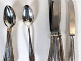 four spoons, a knife, and a spoon on a table