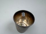 a silver cup that is sitting on a table