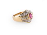 gros plan d'une bague en or avec une pierre en rubis