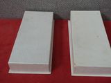 a pair of white boxes sitting on top of a red table