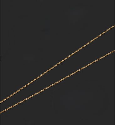 a close up of a gold necklace with a diamond on a black background