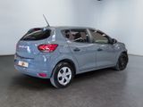 the back of a blue car in a showroom with a white wall