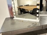 a table that has a mirror on it with lights on it
