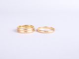a pair of gold wedding rings on a white background